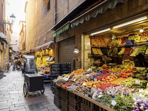 Gastronomical street with market stalls full of fresh local fruits and vegetables in Bologna, Italu